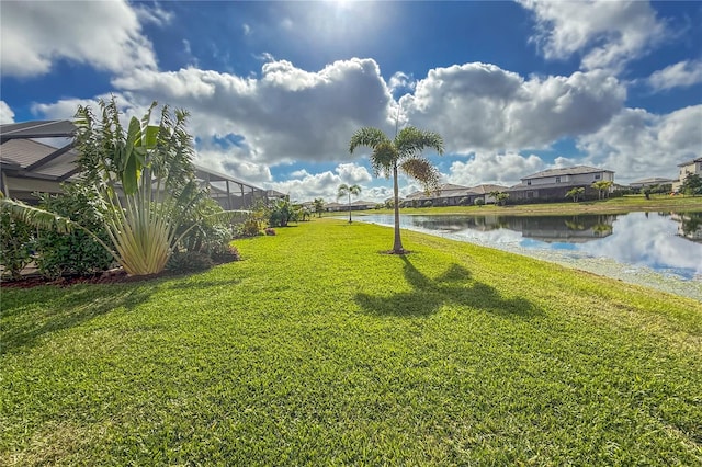 view of yard featuring a lanai and a water view