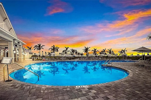 pool at dusk with a patio