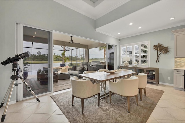 tiled dining space with ceiling fan and ornamental molding