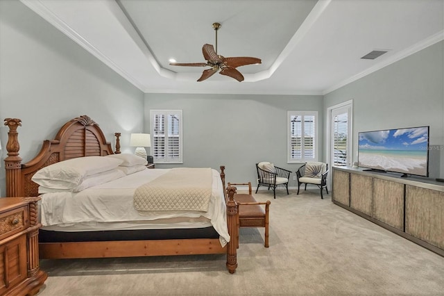 carpeted bedroom featuring ceiling fan, a tray ceiling, and crown molding