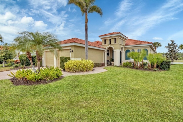 mediterranean / spanish-style home featuring a front yard and a garage