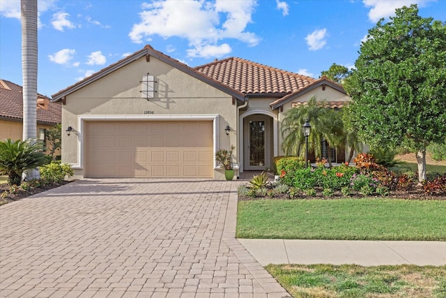 mediterranean / spanish house featuring a front yard and a garage