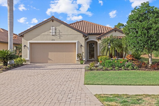 12606 Fontana Loop, Bradenton, FL 34211 - mediterranean / spanish-style house featuring a garage, driveway, stucco siding, a tile roof, and a front yard