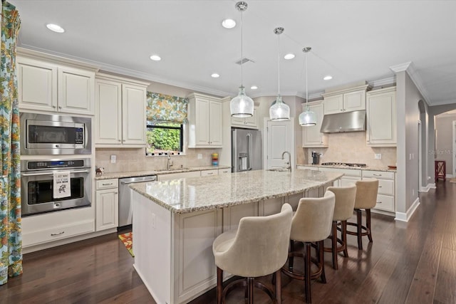 12606 Fontana Loop, Bradenton, FL 34211 - kitchen with stainless steel appliances, under cabinet range hood, crown molding, decorative backsplash, and a kitchen bar