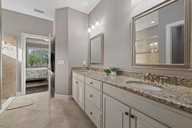 bathroom with tile patterned flooring, vanity, and walk in shower