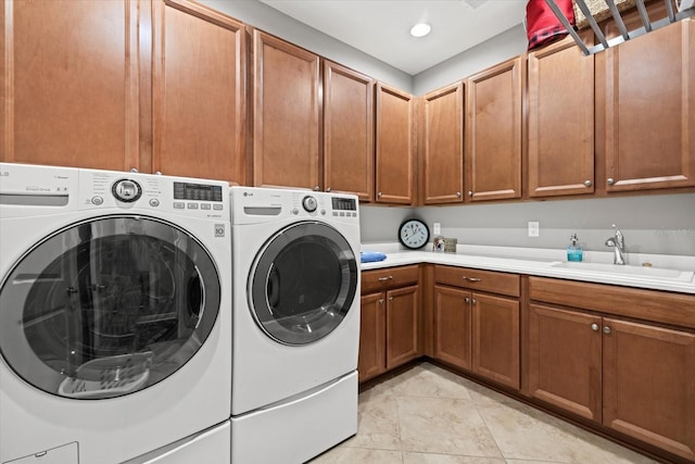 washroom with cabinets, independent washer and dryer, light tile patterned floors, and sink