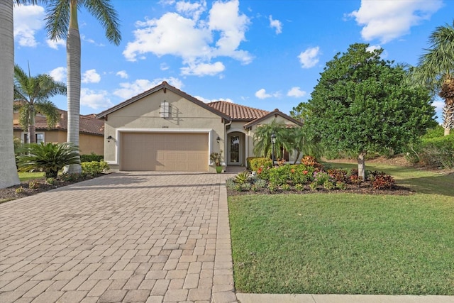 12606 Fontana Loop, Bradenton, FL 34211 - mediterranean / spanish home with an attached garage, decorative driveway, a front lawn, stucco siding, and a tiled roof