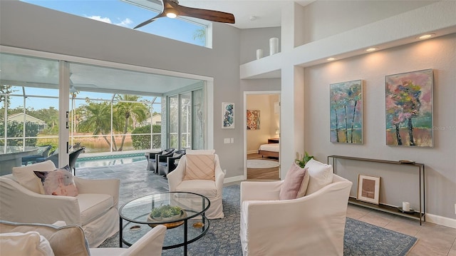 living room featuring ceiling fan, a wealth of natural light, and light tile patterned flooring