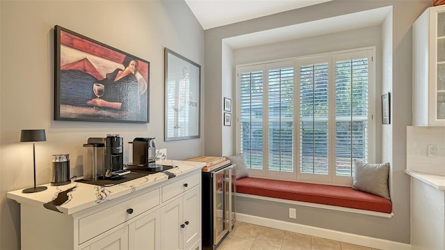 interior space with a wealth of natural light, beverage cooler, and light tile patterned flooring