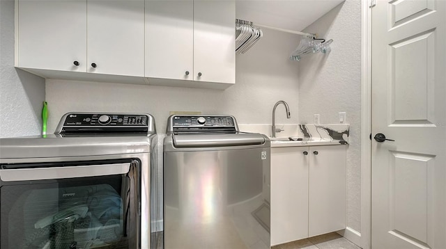 washroom with cabinets, washer and clothes dryer, sink, and light tile patterned flooring