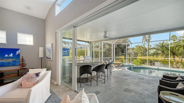 sunroom / solarium featuring lofted ceiling, a water view, and ceiling fan