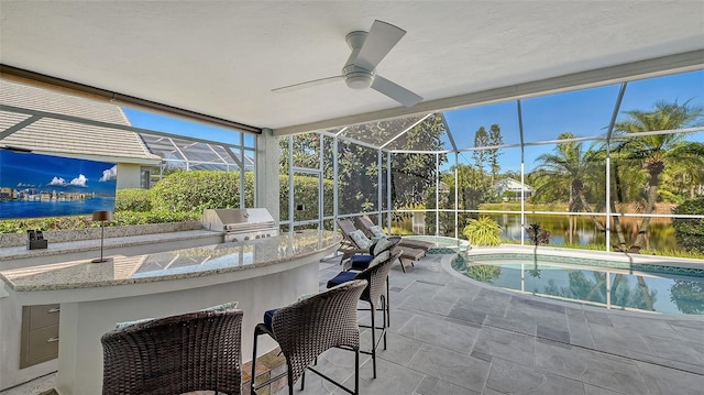 sunroom / solarium featuring ceiling fan and a water view