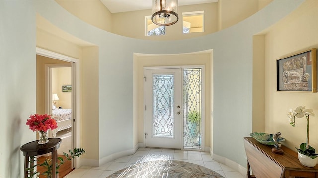 foyer entrance with light tile patterned floors and an inviting chandelier