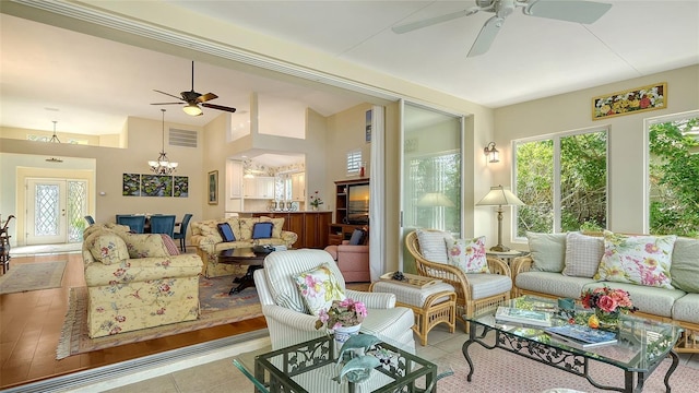 sunroom / solarium featuring ceiling fan with notable chandelier