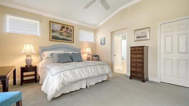 carpeted bedroom with ceiling fan, ensuite bathroom, lofted ceiling, and ornamental molding