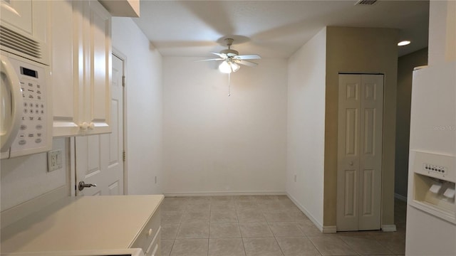 interior space with light tile patterned floors and ceiling fan