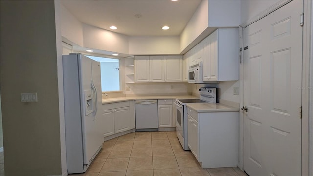 kitchen with light tile patterned floors, white appliances, white cabinetry, and sink