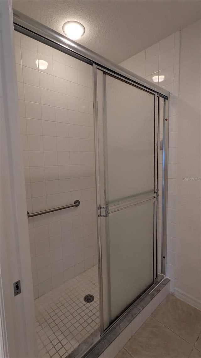 bathroom featuring tile patterned floors, a textured ceiling, and walk in shower