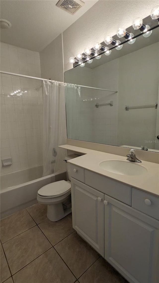 full bathroom with tile patterned flooring, vanity, shower / tub combo, and toilet