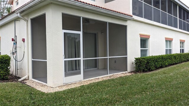 view of property exterior featuring a lawn and a sunroom