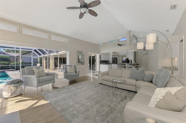 living room featuring ceiling fan, light hardwood / wood-style floors, and plenty of natural light