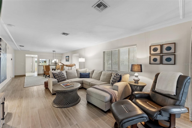 living room with crown molding and light wood-type flooring