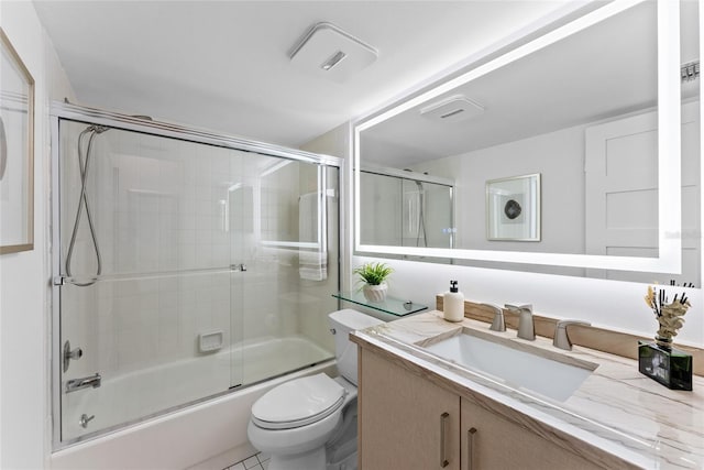 full bathroom featuring enclosed tub / shower combo, vanity, and toilet