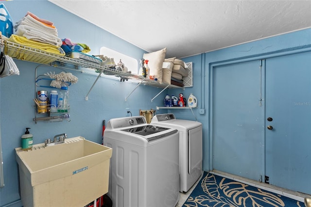 clothes washing area featuring sink and washing machine and clothes dryer