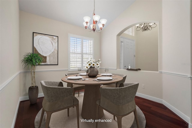 dining space with lofted ceiling, a notable chandelier, and dark hardwood / wood-style floors