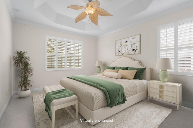 carpeted bedroom featuring multiple windows, ornamental molding, a raised ceiling, and ceiling fan