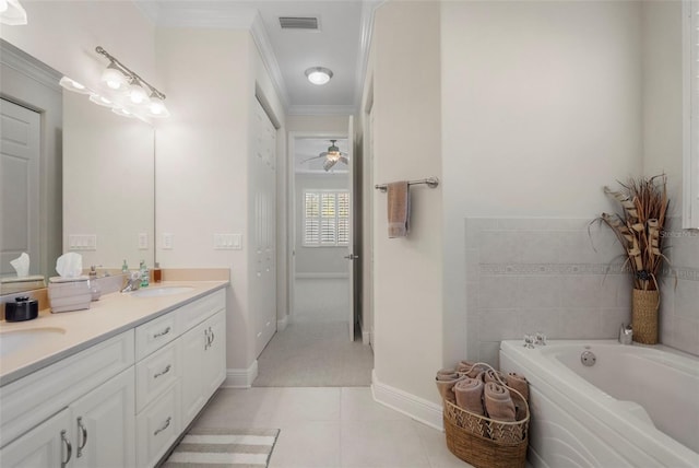 bathroom with tile patterned flooring, ornamental molding, a washtub, and vanity