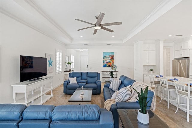 living room featuring a tray ceiling, ceiling fan, and ornamental molding