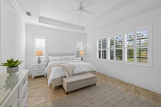 tiled bedroom featuring ceiling fan, ornamental molding, and a tray ceiling