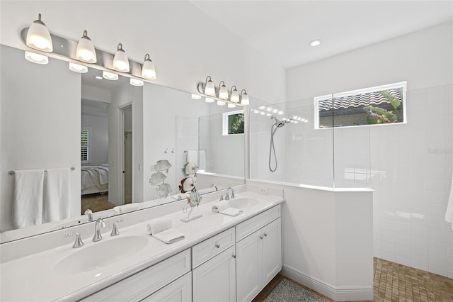 bathroom featuring a tile shower and vanity