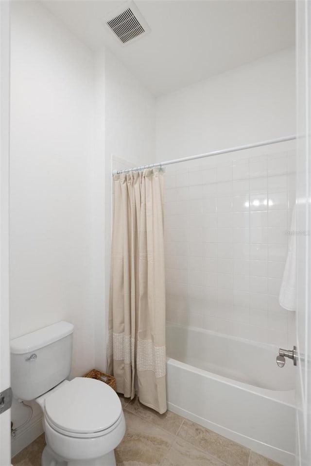 bathroom featuring tile patterned floors, toilet, and shower / tub combo with curtain