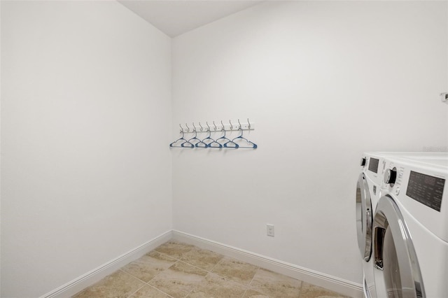 laundry area with washer and clothes dryer and light tile patterned flooring