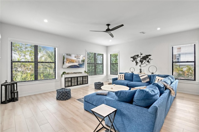 living room featuring ceiling fan and light hardwood / wood-style flooring