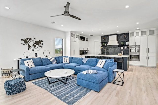 living room featuring ceiling fan and light wood-type flooring