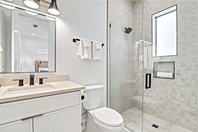 bathroom featuring vanity, toilet, and a shower with shower door