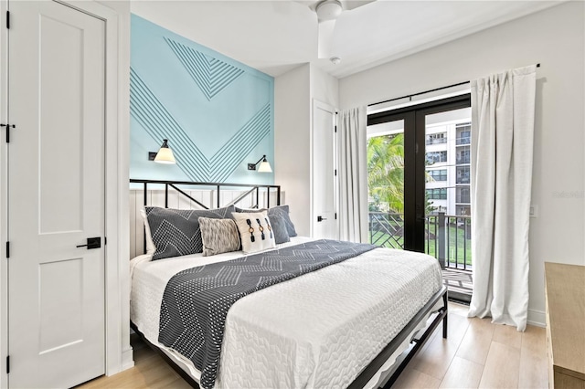 bedroom featuring multiple windows, ceiling fan, french doors, and light wood-type flooring