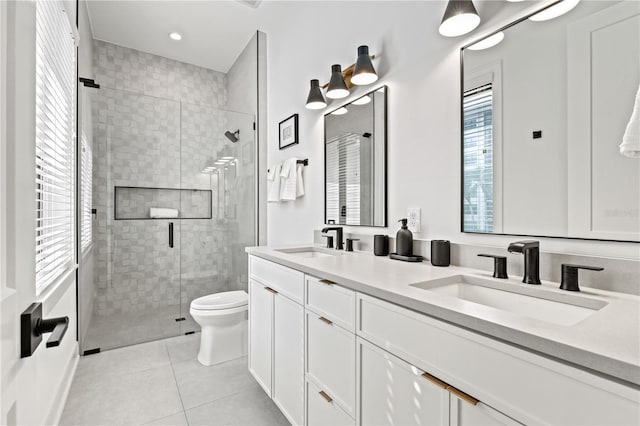 bathroom with tile patterned floors, vanity, an enclosed shower, and toilet