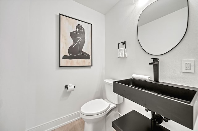 bathroom with hardwood / wood-style floors and toilet