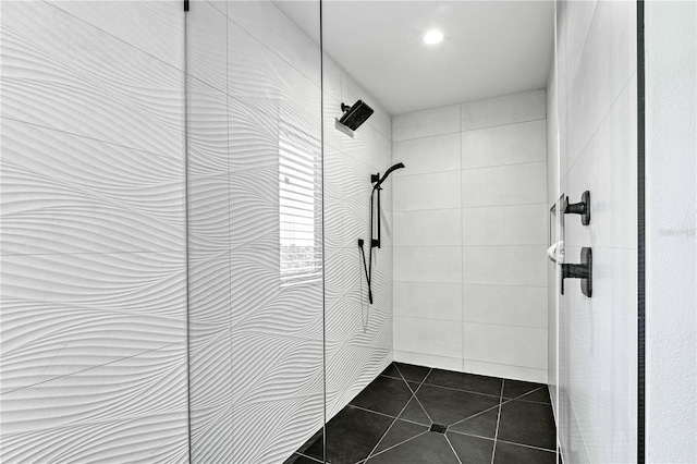 bathroom with tile patterned flooring and a tile shower