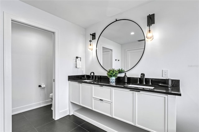 bathroom with tile patterned flooring, vanity, and toilet