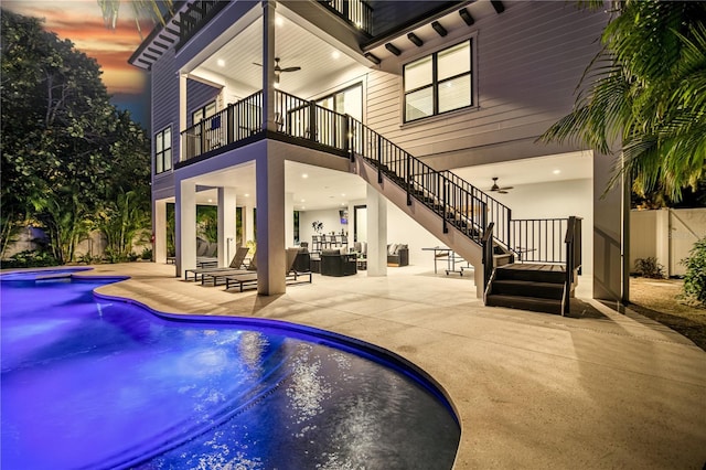 pool at dusk featuring an in ground hot tub, a patio, and ceiling fan