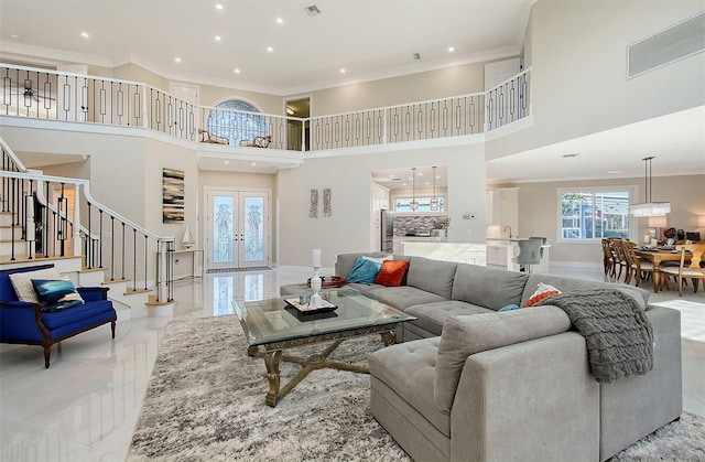 living room featuring french doors, a towering ceiling, and ornamental molding