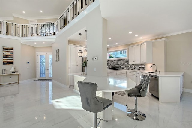 dining space with crown molding, french doors, and sink