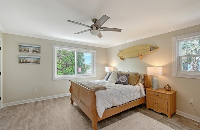 bedroom with ceiling fan, light hardwood / wood-style flooring, and multiple windows