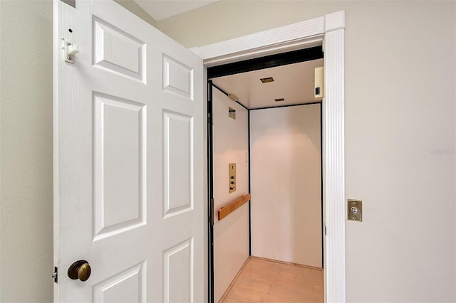 interior space with elevator and hardwood / wood-style flooring