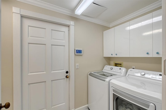 washroom with washer and clothes dryer, cabinets, and crown molding